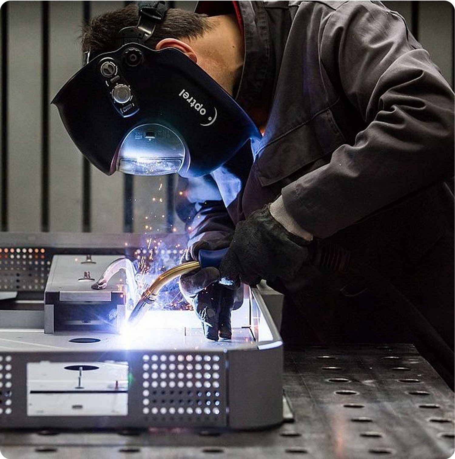Opérateur en train de souder une fontaine POP dans un atelier de fabrication.